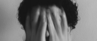 Человек закрывает лицо руками, выражая тревогу или отчаяние