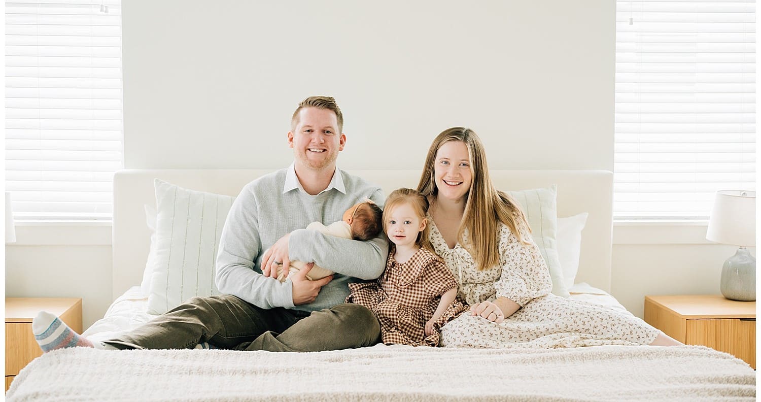 Счастливая семья с двумя детьми обнимается в уютной гостиной