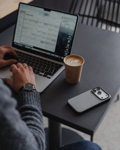 Человек планирует день, дневник и ноутбук на столе