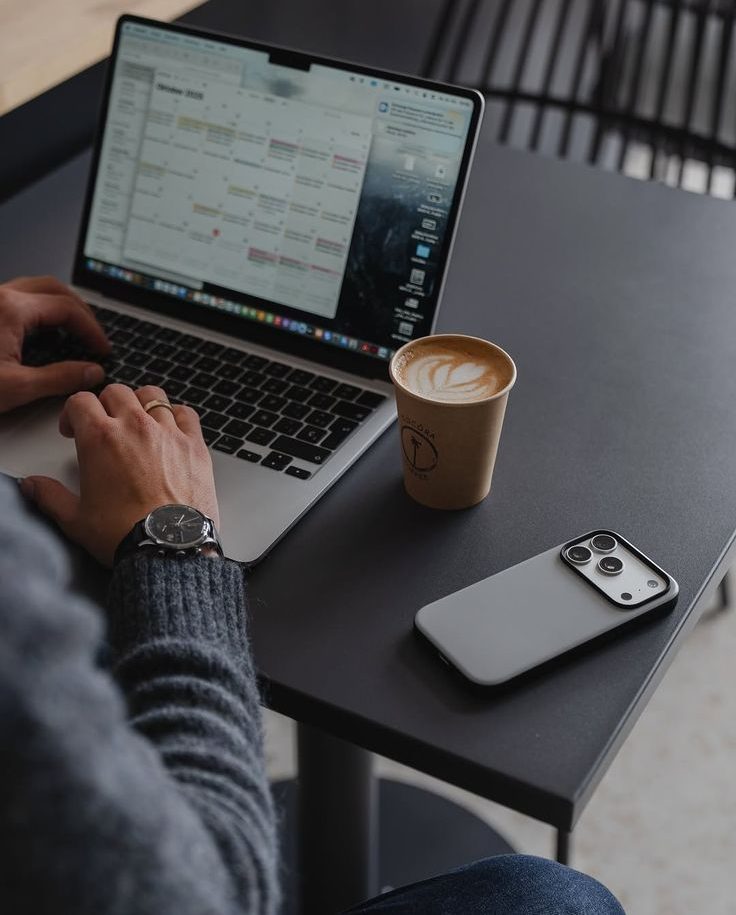 Человек планирует день, дневник и ноутбук на столе